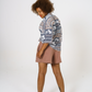 Back view of our relaxed fit aztec inspired printed women shirt, half tucked into our cinnamon Jersey shorts. 