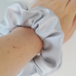 Silver satin scrunchie on wrist