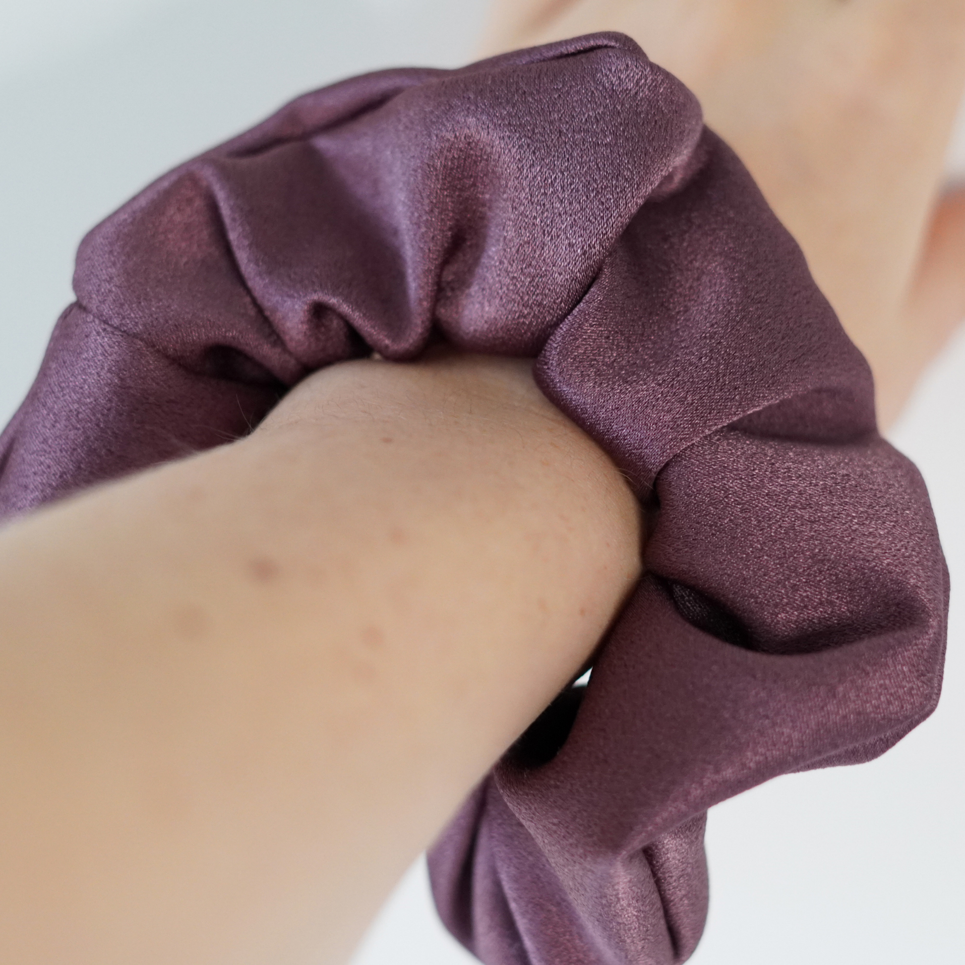 Purple Satin scrunchie on wrist. 