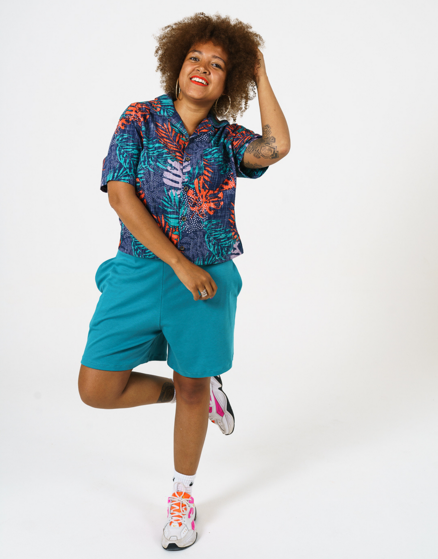 Digital Printed Cotton womens shirt, in bright teal and orange leaf print, paired with our longer length teal Jersey shorts and styles with Bright trainers and socks. 