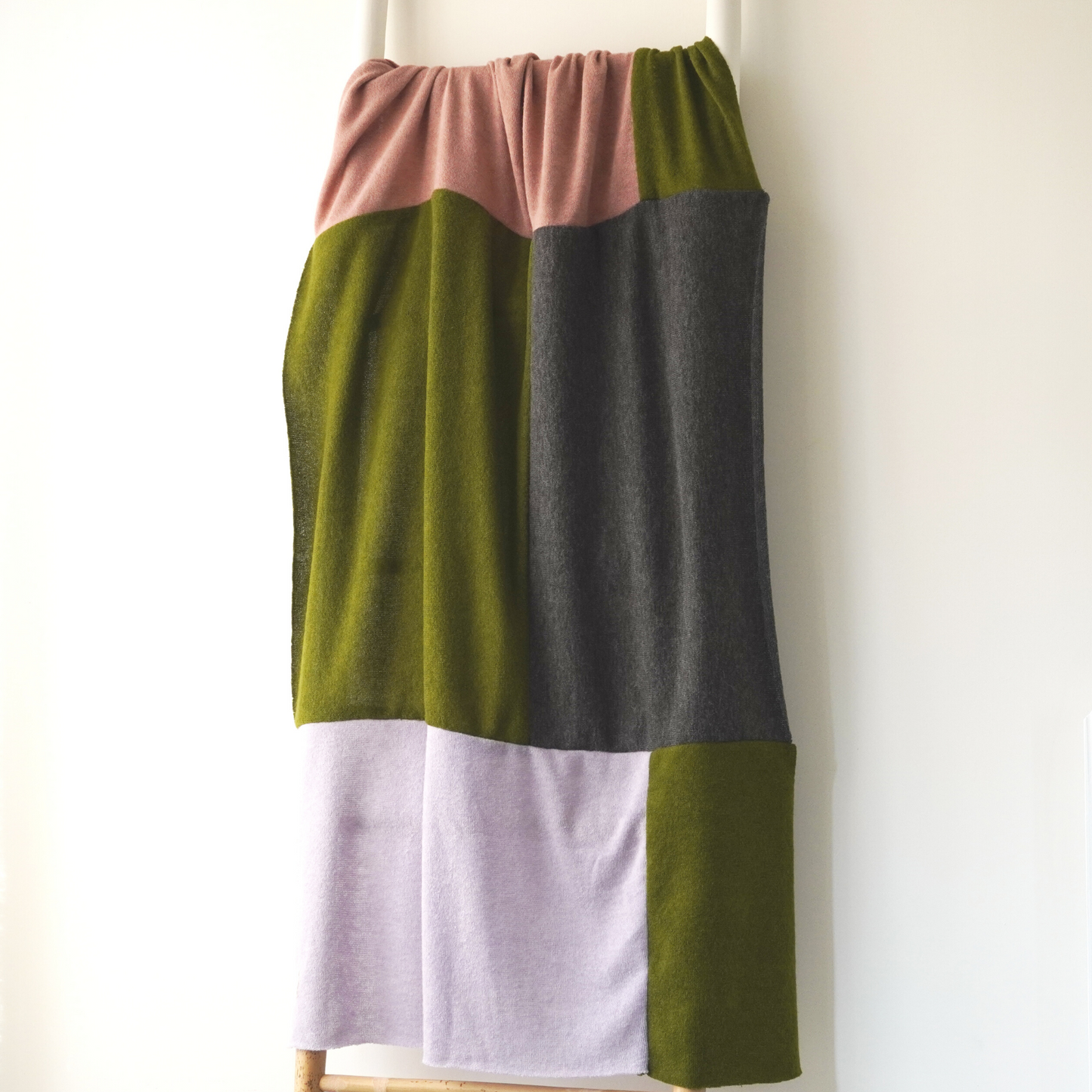 Pink, Green, Lilac and charcoal colour block throw in knit fabric. 