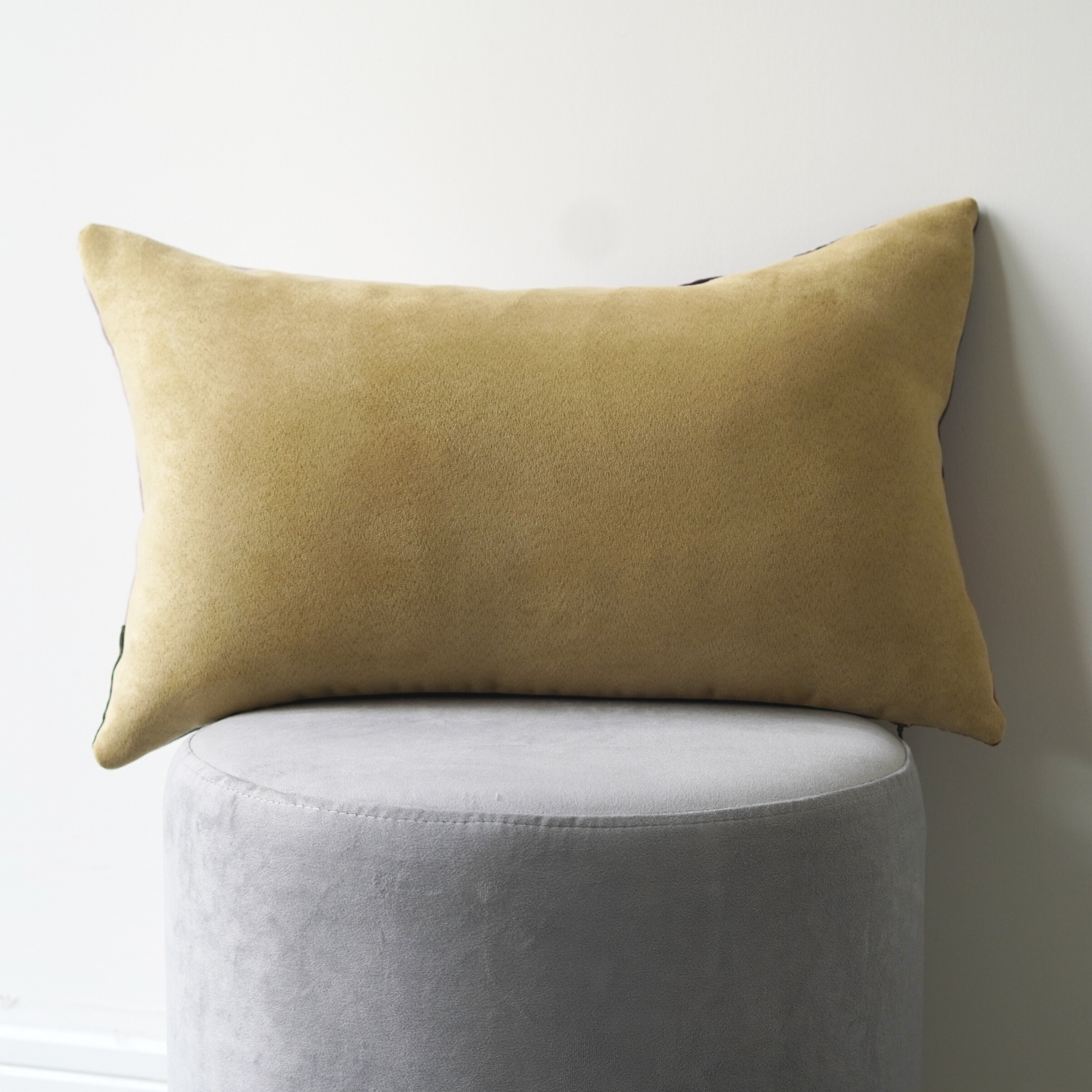 Yellow suede look backing of rectangle cushion. 