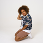 Upcycled womens Navy Floral Viscose Shirt with cropped hem, styled over a white t-shirt and paired with our cinnamon jersey shorts and shown with model kneeling down.  