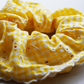 Close up view of yellow and white gingham and broiderie anglaise extra large scrunchie with scalloped edge. 