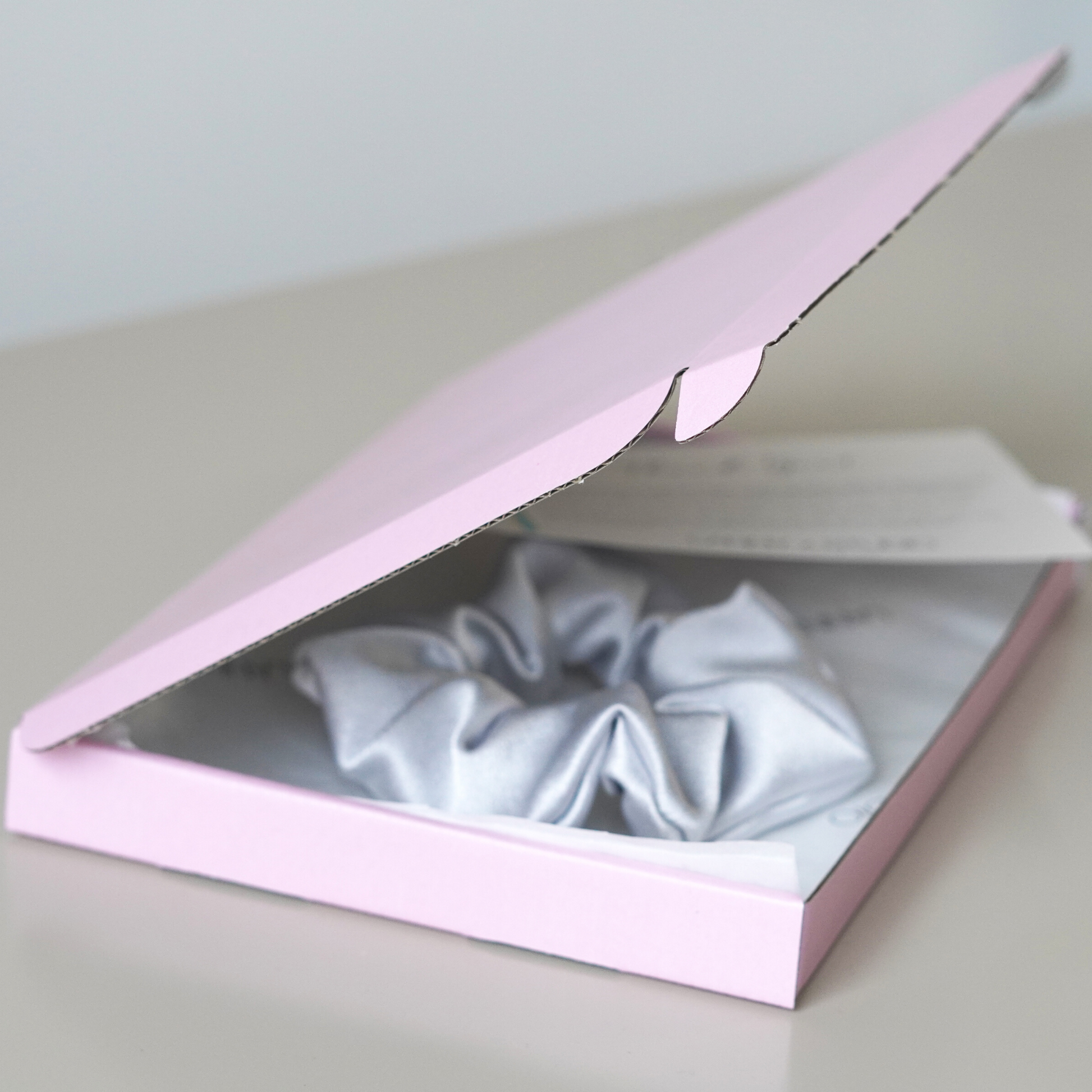 Pink gift box with silver scrunchie. 