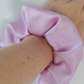 Pink Satin scrunchie on wrist.
