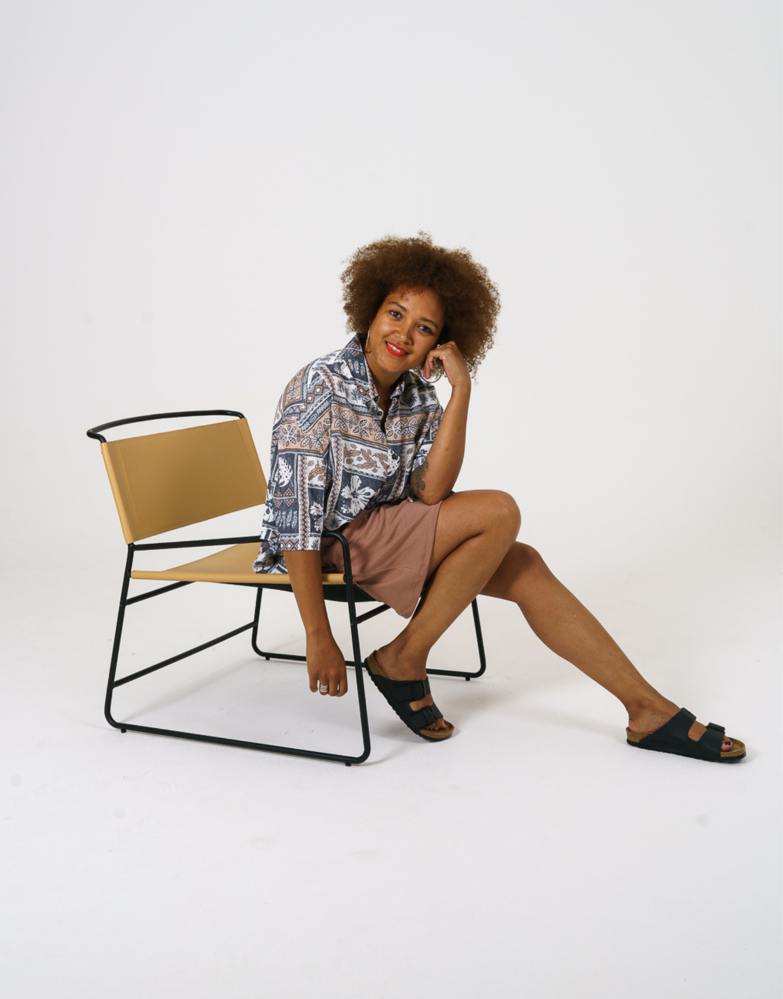 Seated view of our relaxed fit aztec inspired printed women shirt, paired with our cinnamon Jersey shorts. 