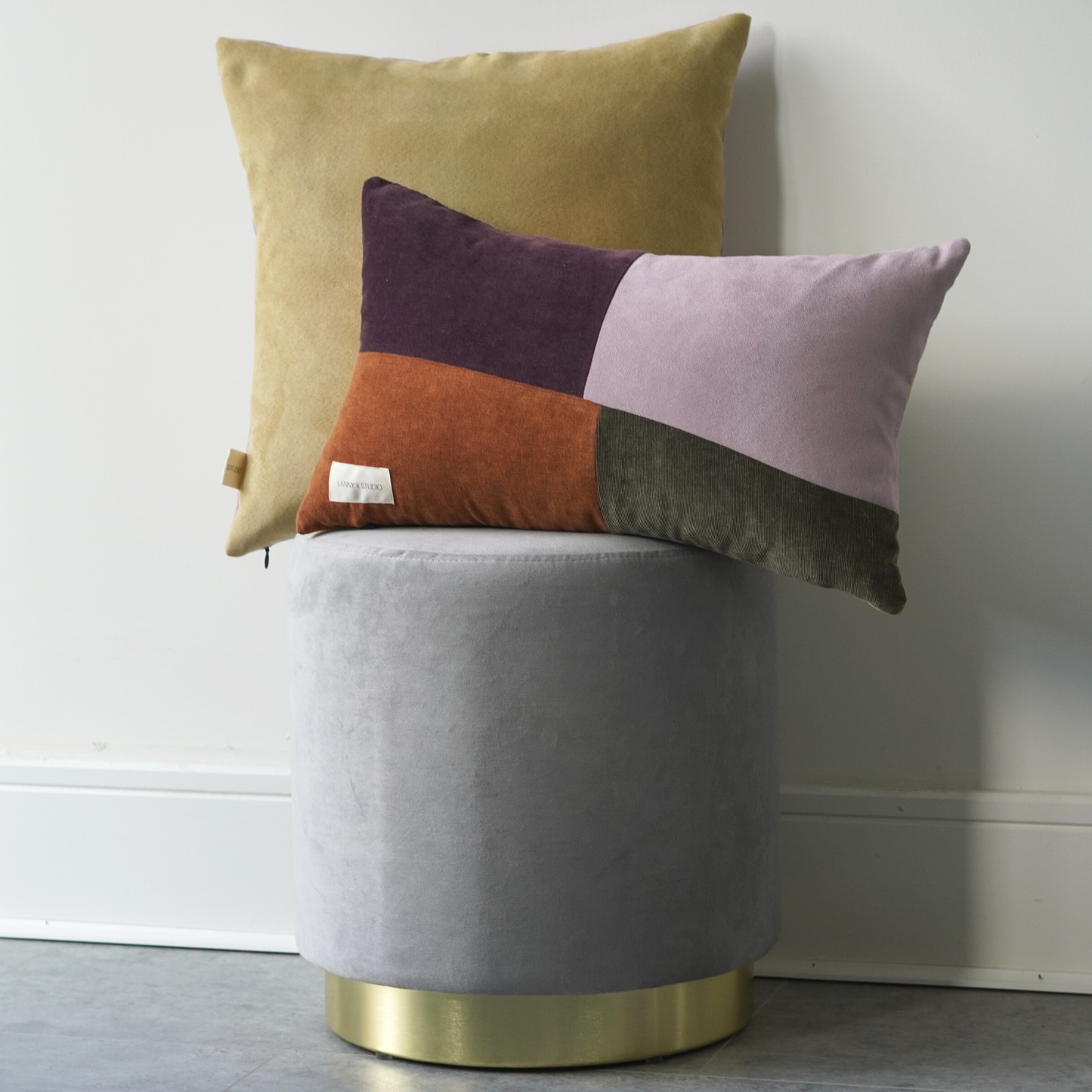 Orange, Purple, Green and Lilac panelled rentable cushion with branded LannyxStudio label partnered with the yellow and lilac suede look square cushion.  